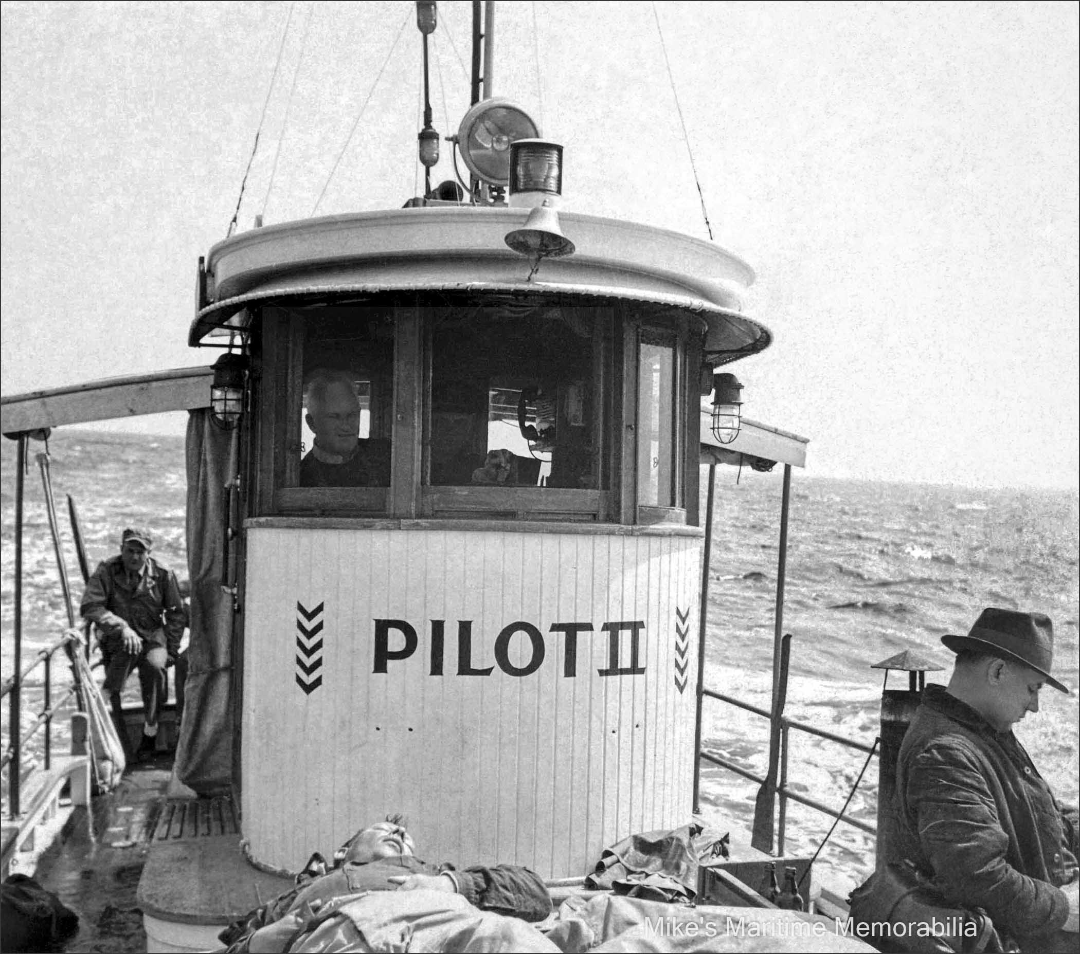 Captain Harry Phillips, PILOT II – 1947 Captain Harry Phillips is shown at the helm of his "PILOT II" while returning to Sheepshead Bay from a day of bottom fishing in October of 1947. Captain Phillips was a 'Master' inshore party boat captain who specialized in bottom and wreck fishing. This photo contains a wealth of details... A burlap bag of fish is tied to the rail near the stern, fishing rods are put away in their canvas bags, a spray curtain is hanging by the wheelhouse, the decks are scrubbed and still wet, a couple of bottles of beer still remain unopened, and the angler at the bottom is taking a quick snooze. Each of the chevrons painted on the wheelhouse denotes a year of coastal patrol service by the boat during World War II. Also notice the neat radiotelephone handset in the wheelhouse.