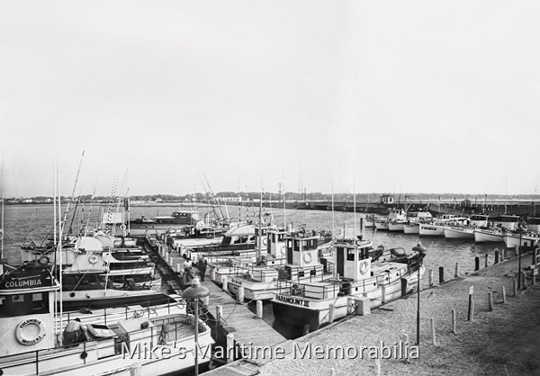 BOGAN'S BASIN FISHING FLEET, Brielle, NJ – 1947 In 1947, Bogan's Basin fishing fleet consisted of ten party and charter boats. Shown here are the "MARAMBO", "COLUMBIA", "PARAMOUNT III", "DIXIE", "PARAMOUNT V", "DAUNTLESS", "ESCORT", "PARAMOUNT II", "PARAMOUNT I" and "FRISCO". Notice the collapsed NJ Route 35 Bridge in the background (the bridge spans on the right have dropped into the water.) The State replaced the old bridge in 1951 and this forced the Bogan Family to reconfigure their boat basin. Photo courtesy of Captain Dave Bogan Sr.