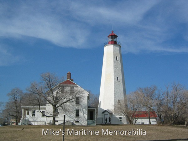 Sandy Hook Lighthouse, Sandy Hook, NJ – 2000 The Sandy Hook Lighthouse [40° 27' 42" N – 74° 00' 06" W] circa 2000. Originally built about 500 feet from the tip of Sandy Hook, NJ, it now stands about 1½ miles from the tip due to the northward expansion of the Hook by ocean currents. Constructed in 1764, the 103 foot tall octagonal mortar covered stone tower was the fifth lighthouse built in America and is the oldest original structure still functioning as a navigational beacon in the United States. Originally, the light had 48 oil burning copper and glass lanterns. In 1856, the light was upgraded with a third order Fresnel lens and it is still in place today. In 1899, the Sandy Hook Lighthouse became the first lighthouse in the country lit by electric lamps. At a ceremony celebrating its 200th anniversary, the lighthouse was dedicated as a National Historic Landmark and is now part of the Gateway National Recreation Area. Its silhouette and warm beam of light is a familiar sight to anglers, mariners and travelers passing in and out of New York harbor. The Sandy Hook Lighthouse reopened to the public Sunday, June 24, 2018 after a nine-month renovation that refurbished the interior and exterior of the 254-year-old beacon. It is now open daily to the public with free half hour tower tours running from 1 to 4:30 p.m. Tour groups are kept small due to space constraints inside the tower and tour patrons must be at least 4 feet tall to ascend the tower.